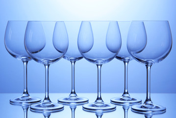 Empty wine glasses arranged on blue background