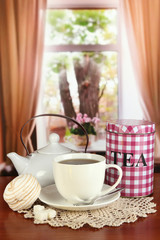 Jar and cup of tea on table in room