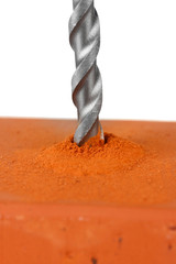 Close-up image of drilling hole on brick, isolated on a white