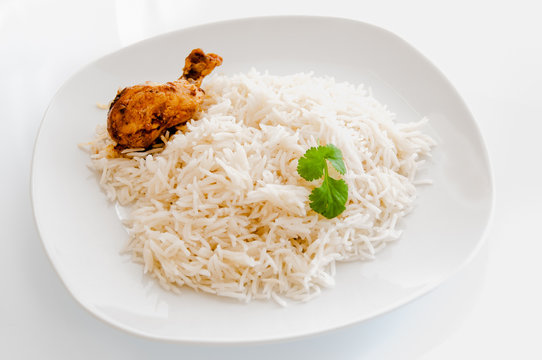 Cooked rice with chicken and corriander on white background