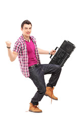 Full length portrait of a young man holding a radio and gesturin