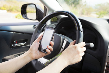 smart phone in hand  while driving the car