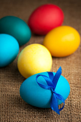 Obraz na płótnie Canvas colored Easter eggs on the burlap background