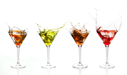 Serial arrangement of coloured liquids splashing in cocktail gla