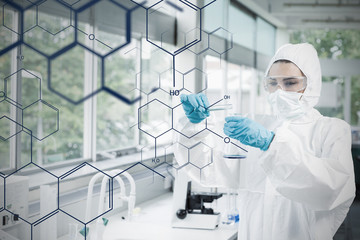 Chemist in protective suit working with futuristic interface wit