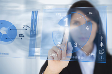 Serious businesswoman using blue pie chart futuristic interface