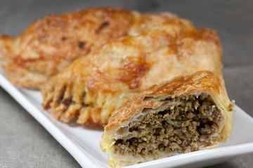 Piroggen mit Hackfleisch gefüllt auf weißem Teller