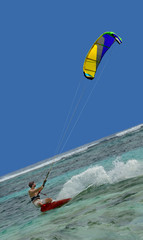 Speedy surfing man, colorful kite.