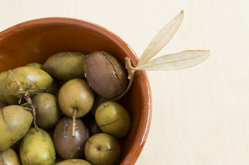 green spanish olives in a ceramic container in close up