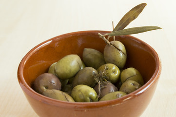 green spanish olives in a ceramic container