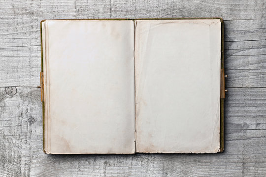 Altes Buch mit leeren Seiten vor Holzhintergrund