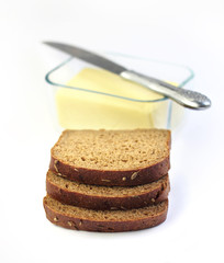 Slices of rye bread and butter in a glass container on backgroun