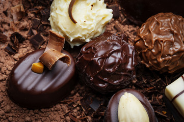 chocolate pralines on dark chocolate background