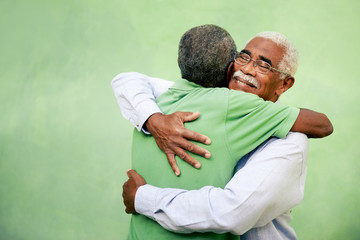 Old friends, two senior african american men meeting and hugging