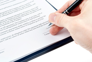 Hand with a pen signing an agreement