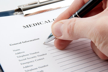 Hand with a pen filling in medical questionnaire form