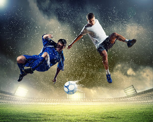 Obraz na płótnie Canvas dwa piłkarskie gracze uderzają piłkę