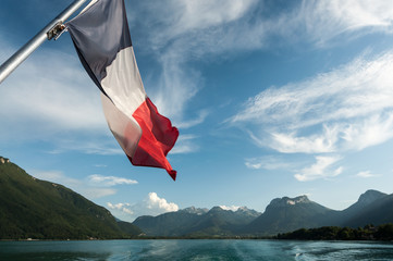 View from a boat on the Annecy Lake with the french flag