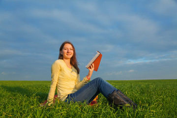 Teen girl reading the Bible outdoors