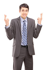 Young businessman posing with fingers crossed for good luck