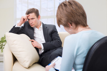 Depressed man talking with psychologist