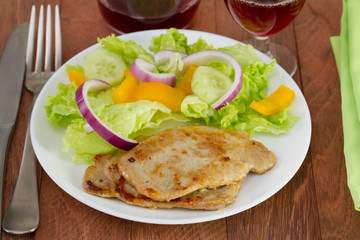 fried pork with salad on the plate