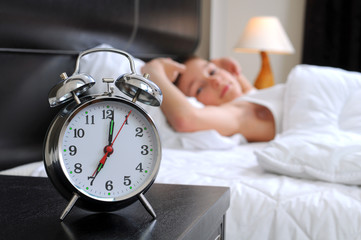 Sleeping boy with alarm clock in front