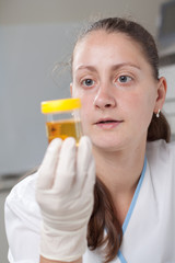 Woman examine urine container