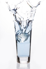 Big ice cube falling in a filled glass