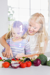 Mother and daughter chopping vegetables with holographic interfa