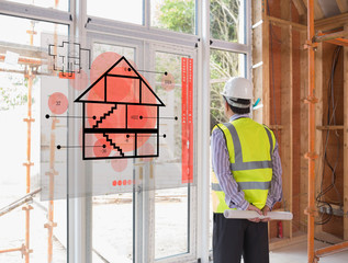 Architect looking out window with red hologram interface in fore