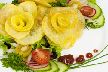 French fries in the form of a rose on a plate with a salad