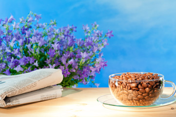 Kaffeetasse mit Kaffeebohnen und Zeitung