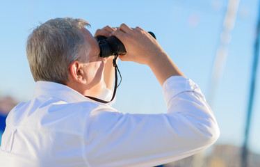 Mature Man Looking Through Binocular