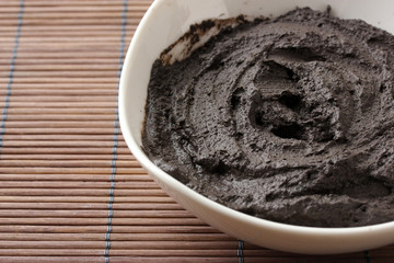 Cosmetic clay for spa treatments, on bamboo background