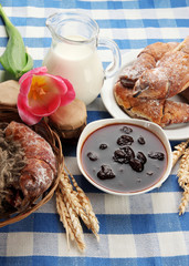Taste croissants, milk and jam, on tablecloth.