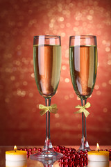 Two glasses of champagne on bright background with lights