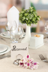 Reserved sign on restaurant table with empty dishes and glasses