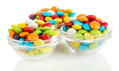 Colorful candies in glass bowls isolated on white