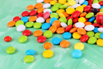 Colorful candies on green background