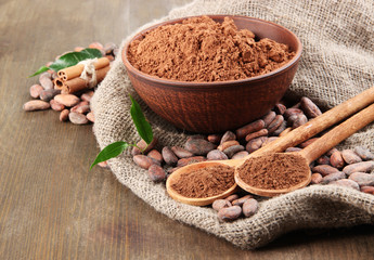 Cocoa powder and cocoa beans  on wooden background
