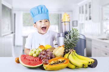 Happy boy blends healthy fruit juice at home