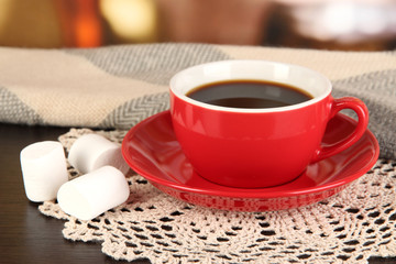 cup of coffee with scarf on table in room