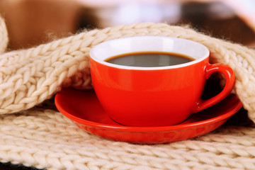 cup of coffee with scarf on table in room