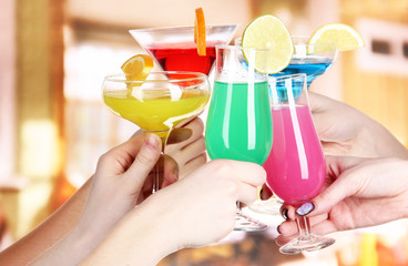 Cocktails in hands in cafe