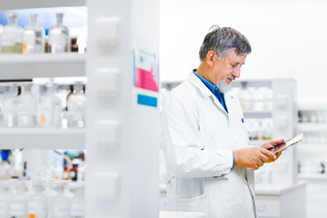 Senior doctor/scientist using his tablet computer at work