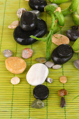 Beautiful bamboo branches with stones for spa on wooden table