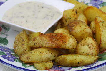Fried potato wedges with garlic dip on the side