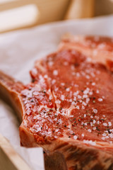 Bone-in Rib eye Steak steak on paper and wooden table