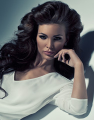 Vogue style photo of very delicate brunette with necklace